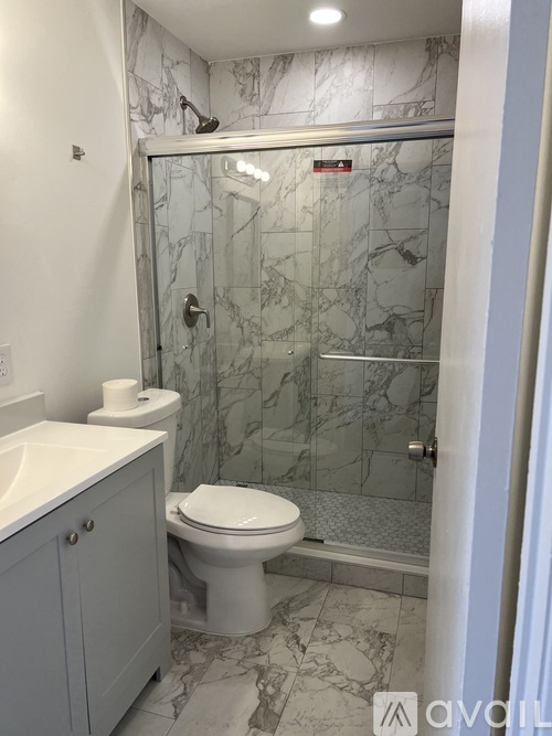 A bathroom with a marble shower and toilet.