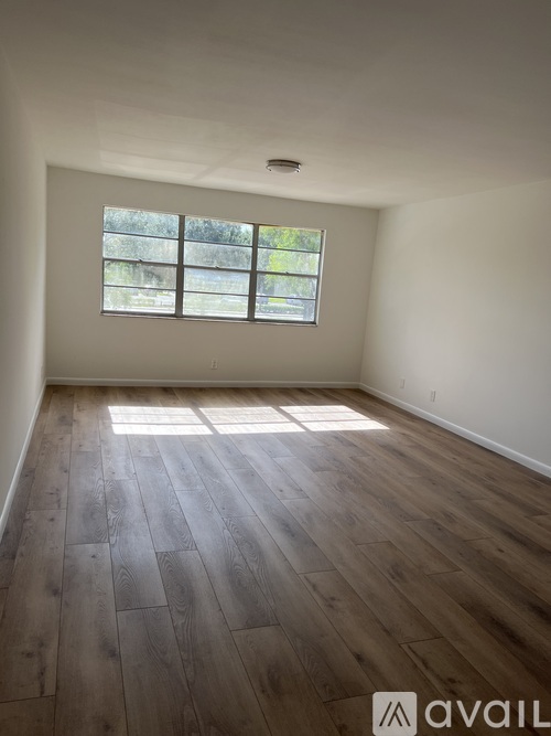 A room with wooden flooring and a window.