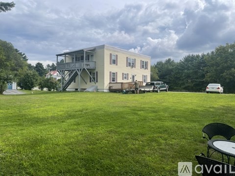 A house with a balcony and a car parked in front.