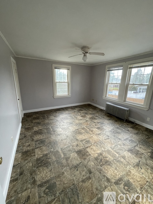 A room with a ceiling fan and tiled flooring.