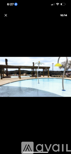 A pool with a diving board and a yellow umbrella.