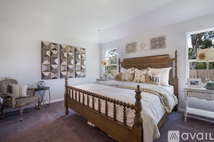 A bedroom with a large bed and a chair.