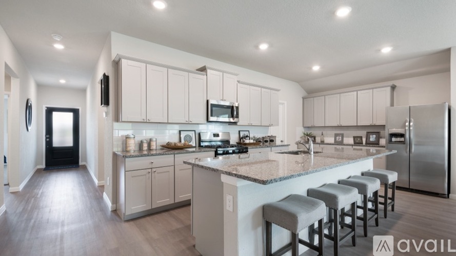 A kitchen with white cabinets and a marble countertop.
