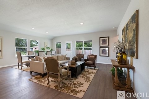 A living room with a brown rug and a brown coffee table.
