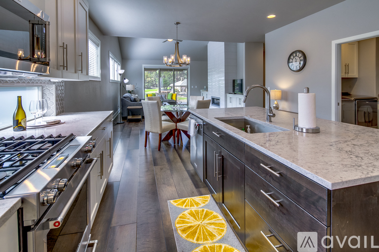 A modern kitchen with a stove top oven and a marble counter top.