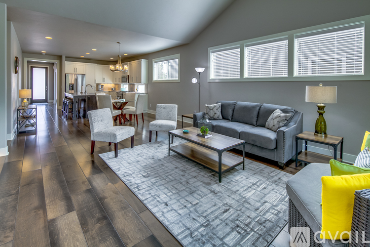 A modern living room with a grey couch and a wooden floor.