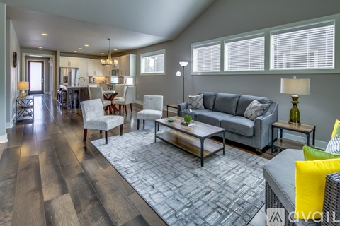 A modern living room with a grey couch and a wooden floor.