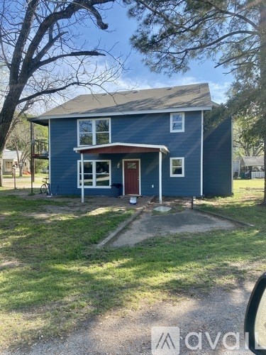 A blue house with a red door and a brown roof.