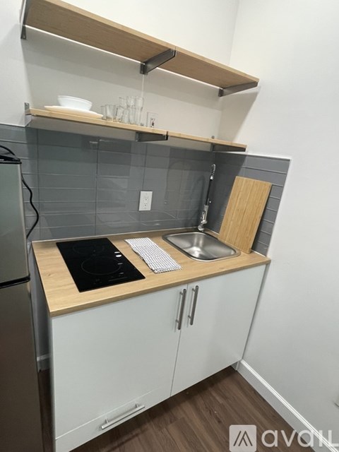 A kitchen with a stove top oven and a sink.