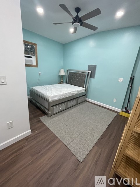 A bedroom with a bed, a ceiling fan, and a rug.
