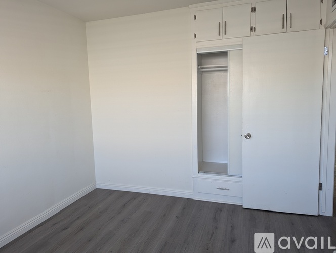 A room with a white door and a white cabinet above it.
