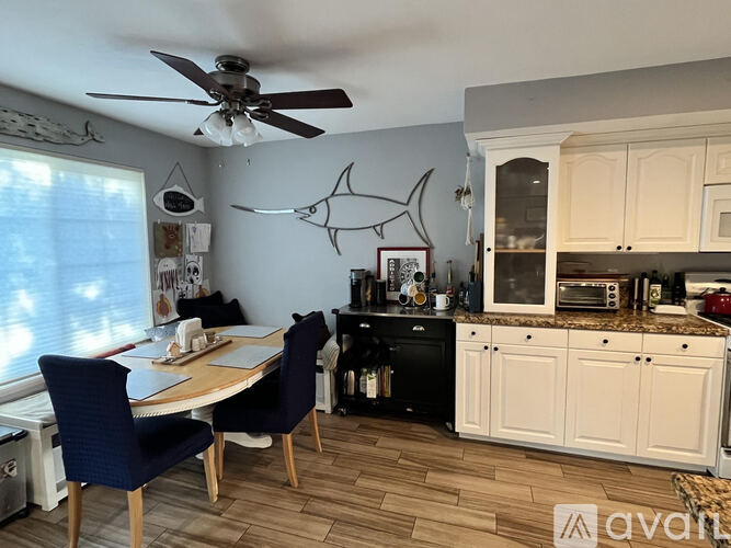 A kitchen with a table and chairs and a ceiling fan.
