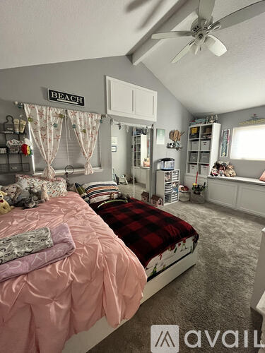 A bedroom with a bed, a ceiling fan, and a sign that says "BEACH".