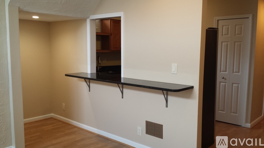 A room with a black shelf and a white door.