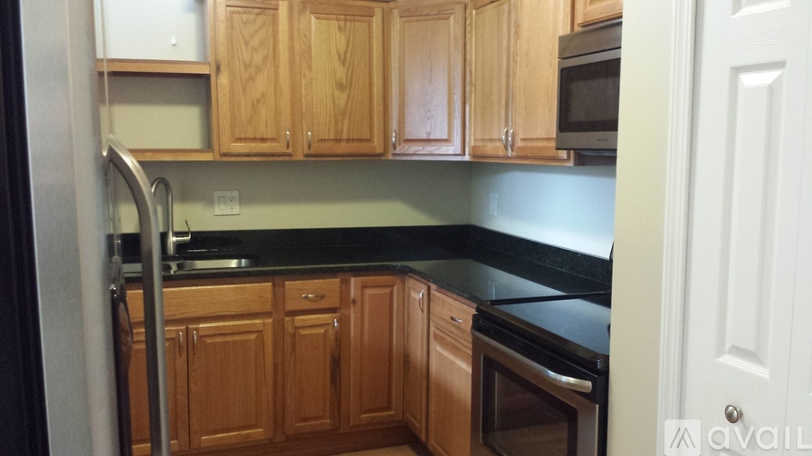 A kitchen with wooden cabinets and a black countertop.