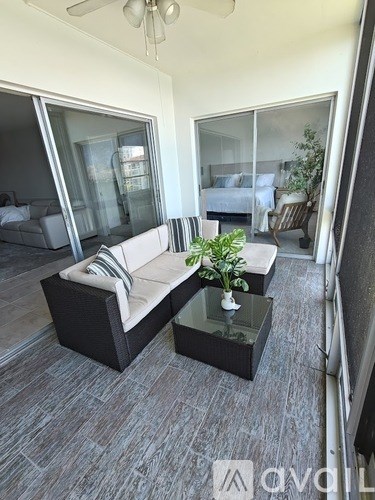 A living room with a grey sofa and a glass table.