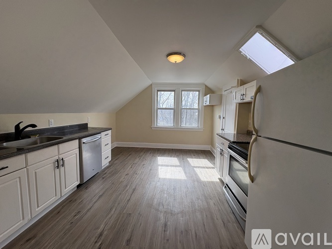 A kitchen with wooden floors and white cabinets.