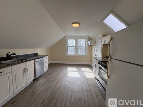 A kitchen with wooden floors and white cabinets.
