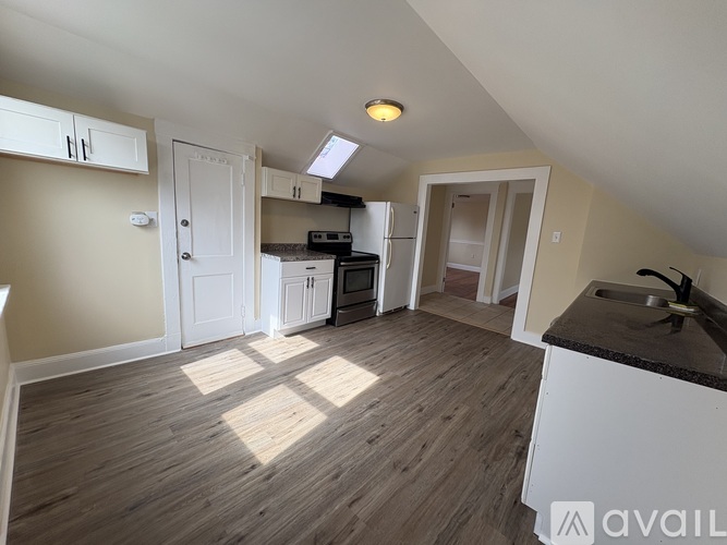 A kitchen with wooden floors and white appliances.
