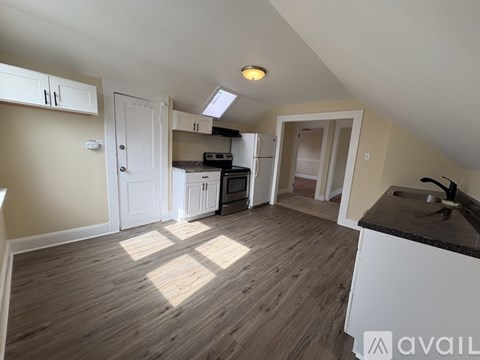 A kitchen with wooden floors and white appliances.