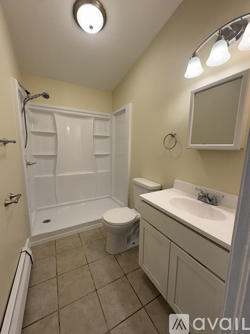 A bathroom with a toilet, sink, and shower.