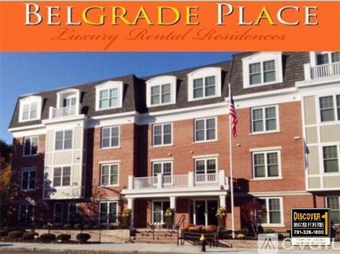 A large brick building with a balcony and an American flag on it.