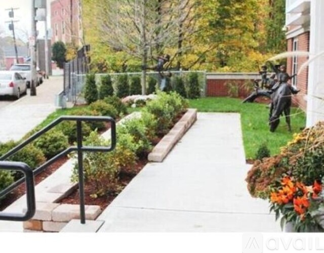 A statue of a person on a horse is in the middle of a grassy area.