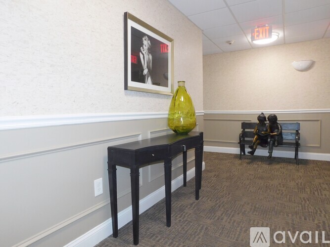 A yellow vase sits on a black table in a room with a wheelchair.