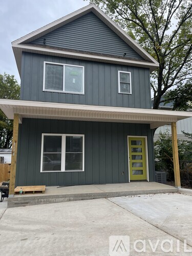 A house with a grey exterior and a green door.
