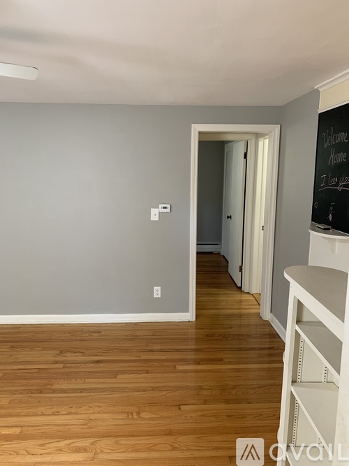 A room with wooden floors and a white shelf.