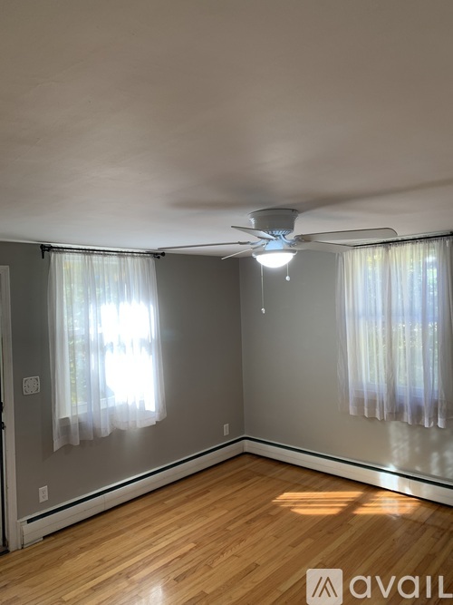 A room with wooden floors and a ceiling fan.