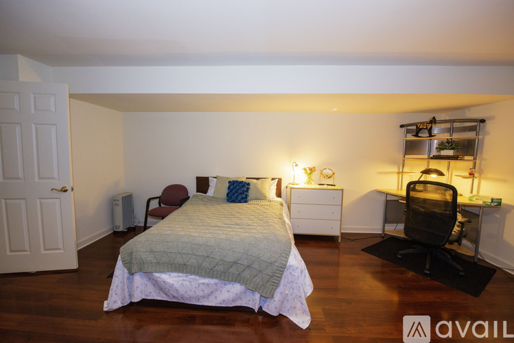 A bedroom with a bed, desk, and chair.