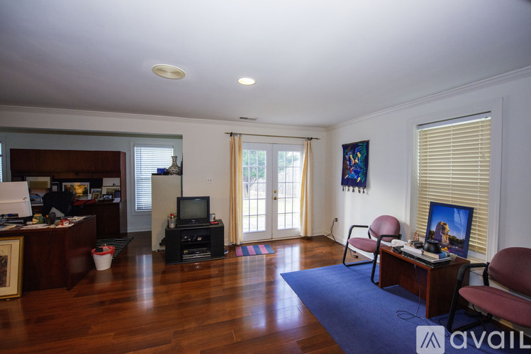 A living room with a television, a chair, and a painting on the wall.
