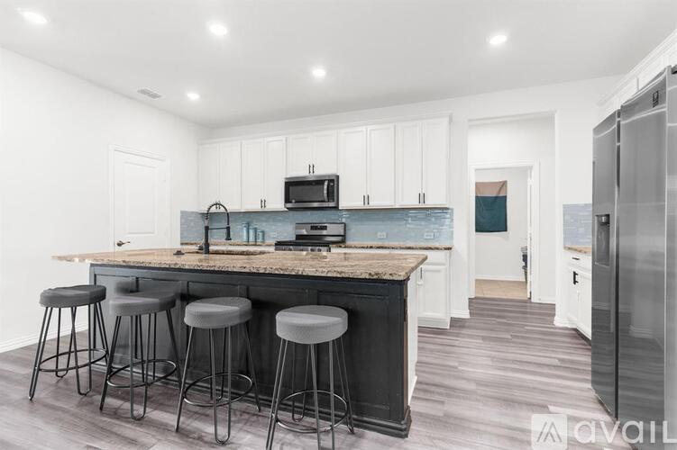 A kitchen with a granite countertop and bar stools.
