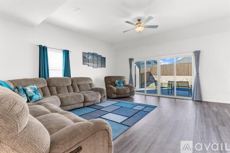 A living room with a large sectional sofa and a ceiling fan.