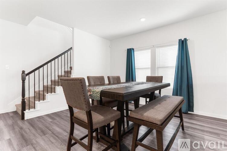 A dining room with a table and chairs.