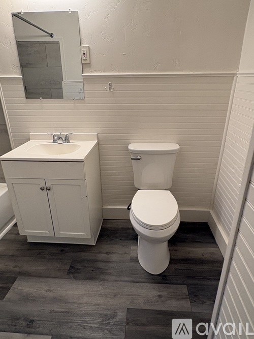 A white toilet sits next to a sink in a small bathroom.