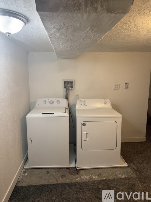 Two white washing machines in a small room.