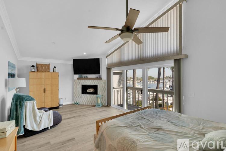 A bedroom with a large bed and a television mounted on the wall.