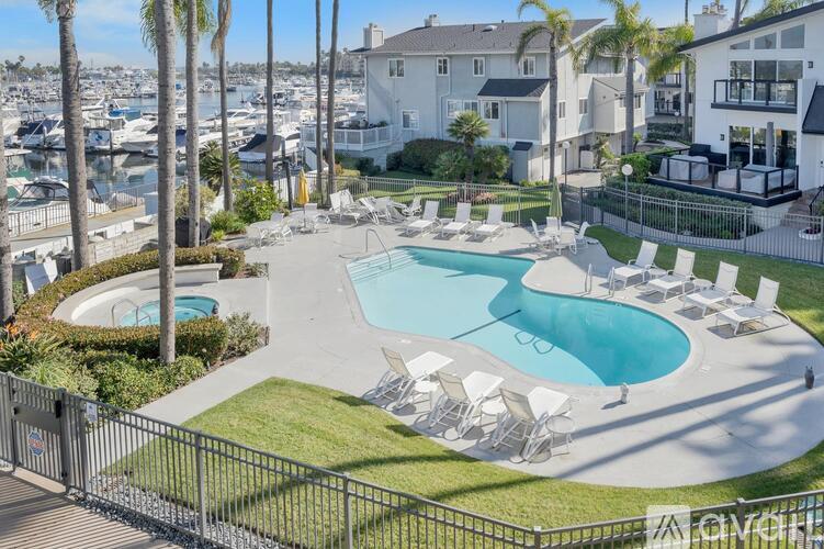 A pool surrounded by chairs and a fence with the word "ANCHOR" on it.
