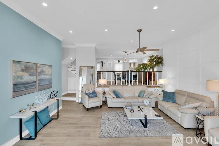 A living room with a white couch, a coffee table, and a painting on the wall.