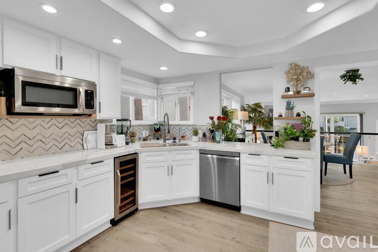A modern kitchen with white cabinets and a patterned backsplash.