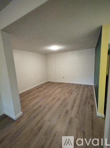A room with wooden flooring and white walls.