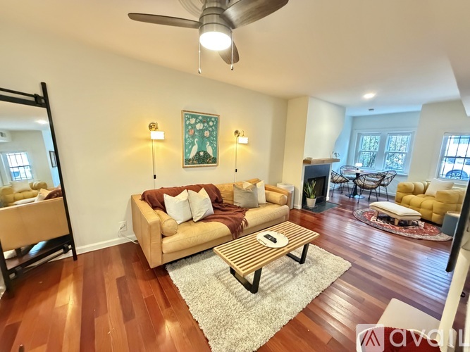 A living room with a wooden floor and a beige sofa.