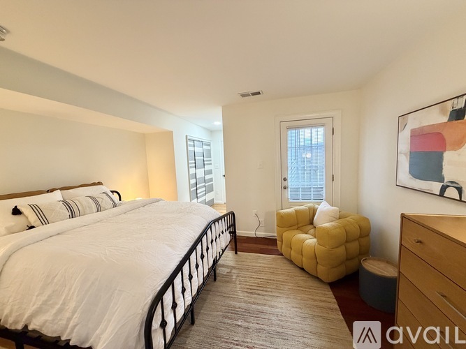 A bedroom with a large bed and a yellow chair.