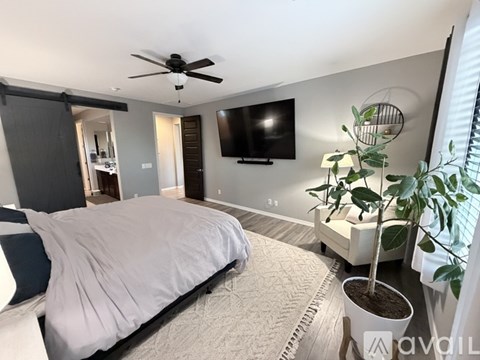 A bedroom with a large bed and a flat screen TV mounted on the wall.