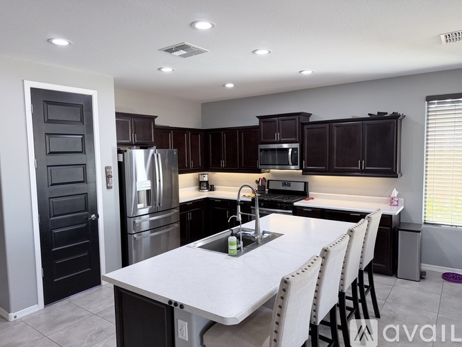 A modern kitchen with a white table and black cabinets.