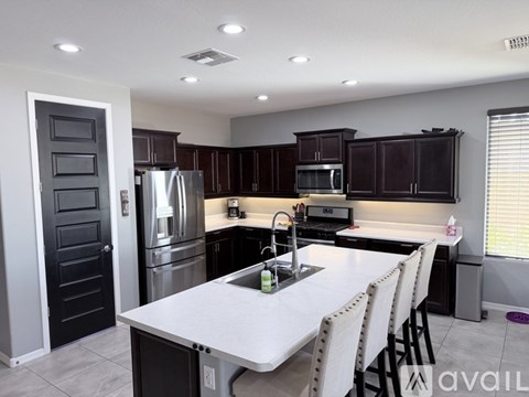 A modern kitchen with a white table and black cabinets.