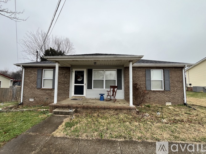 A house with a front porch and a blue bucket on it.