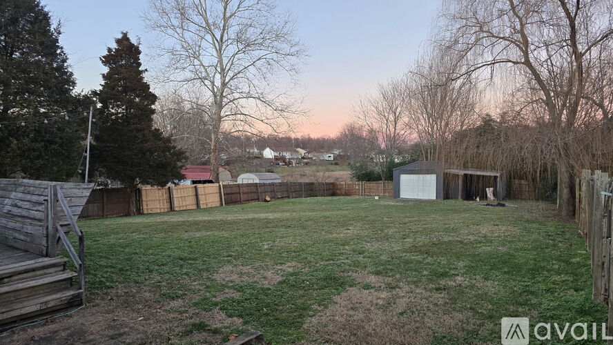 A backyard with a wooden deck and a fence.